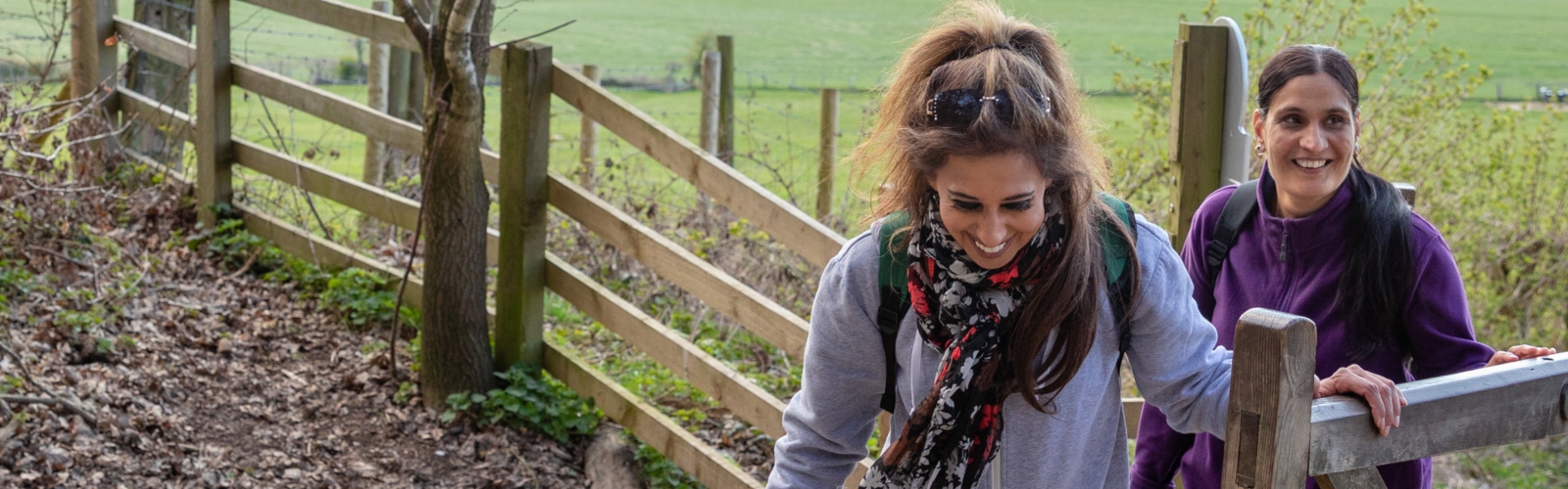 Two women laugh while walking in the countryside