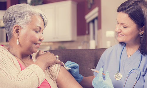 Nurse giving flu jab to woman