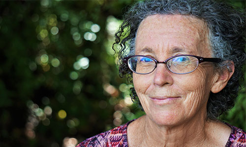 Woman with glasses smiling at camera